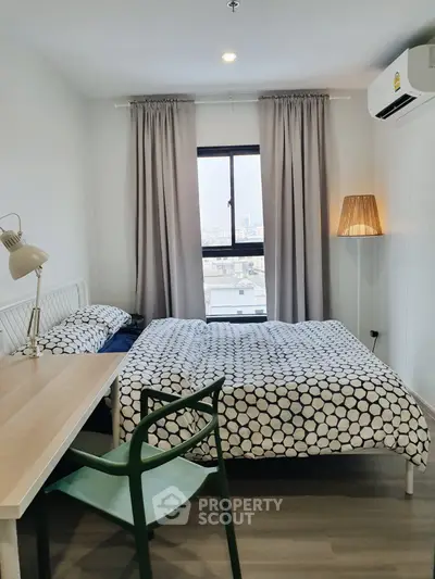 Cozy bedroom with modern decor and city view window.