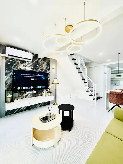 Modern living room with stylish lighting and sleek staircase in a contemporary home.