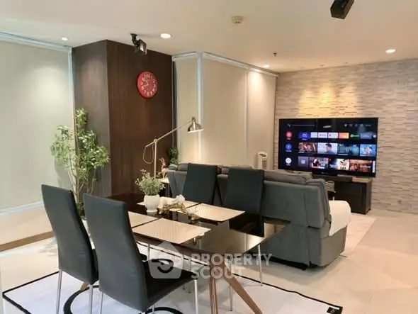 Modern living room with sleek dining area and large TV screen, perfect for entertainment.