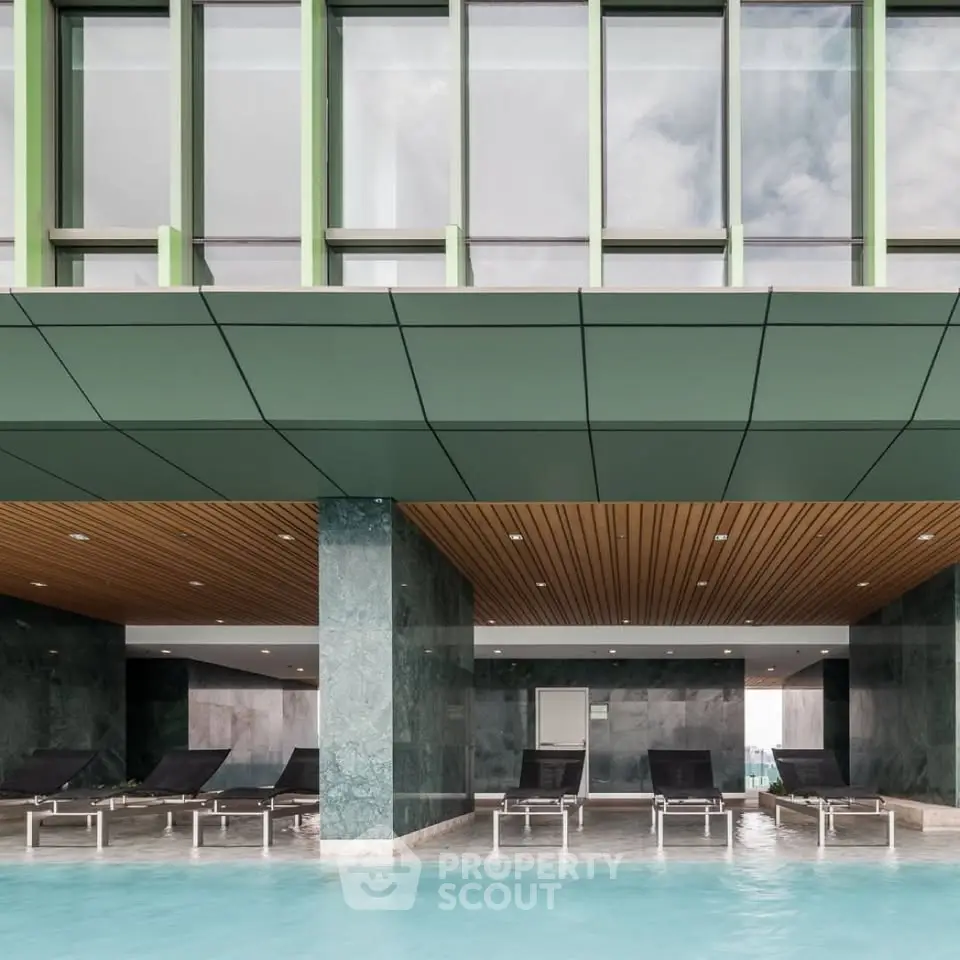 Luxurious modern pool area with sleek design and sun loungers in a high-end residential building.