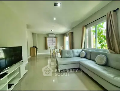 Spacious living room with modern sofa and large windows for natural light.