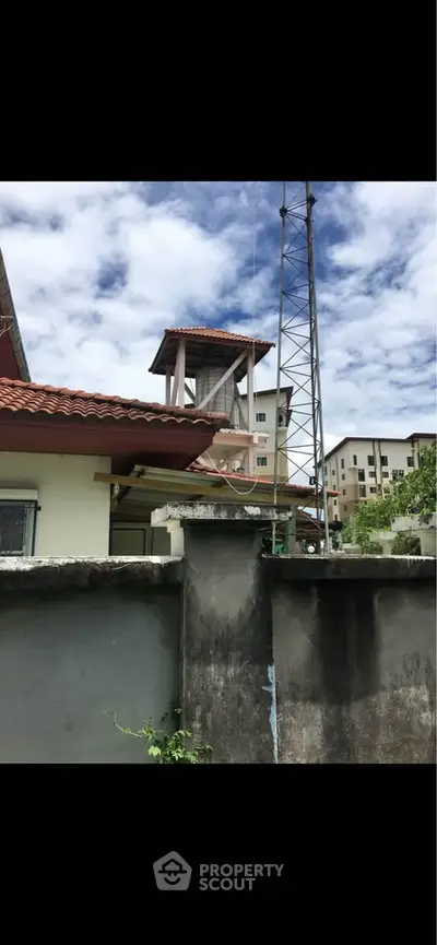 Charming residential building with unique architectural features and lush surroundings.