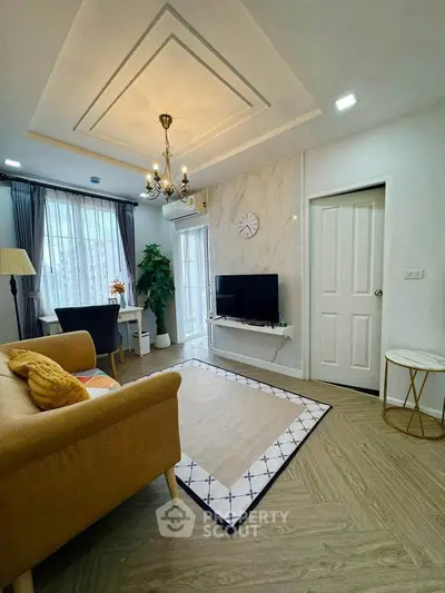Stylish living room with modern decor, elegant chandelier, and cozy seating area.