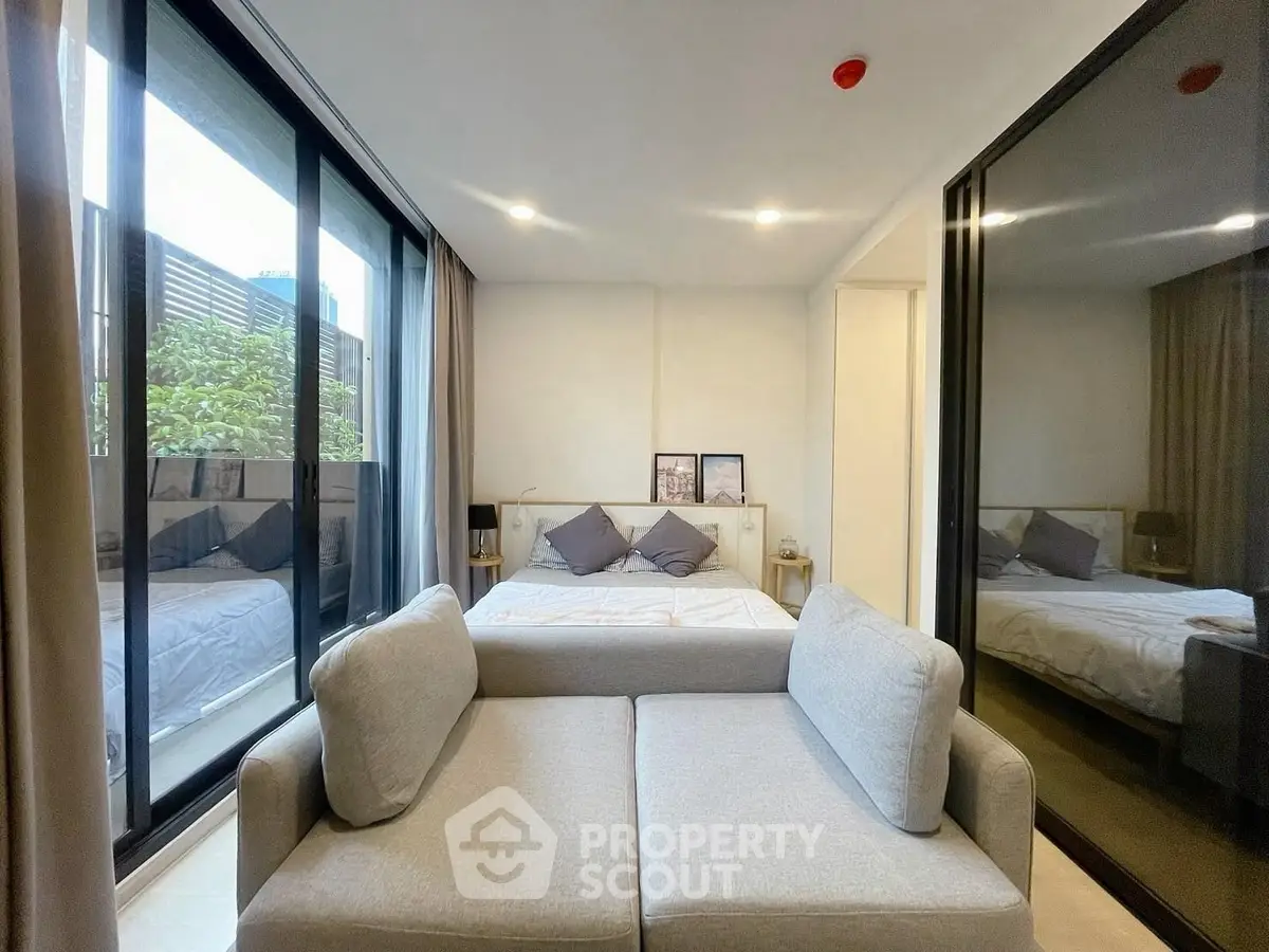 Modern bedroom with glass wall and cozy seating area