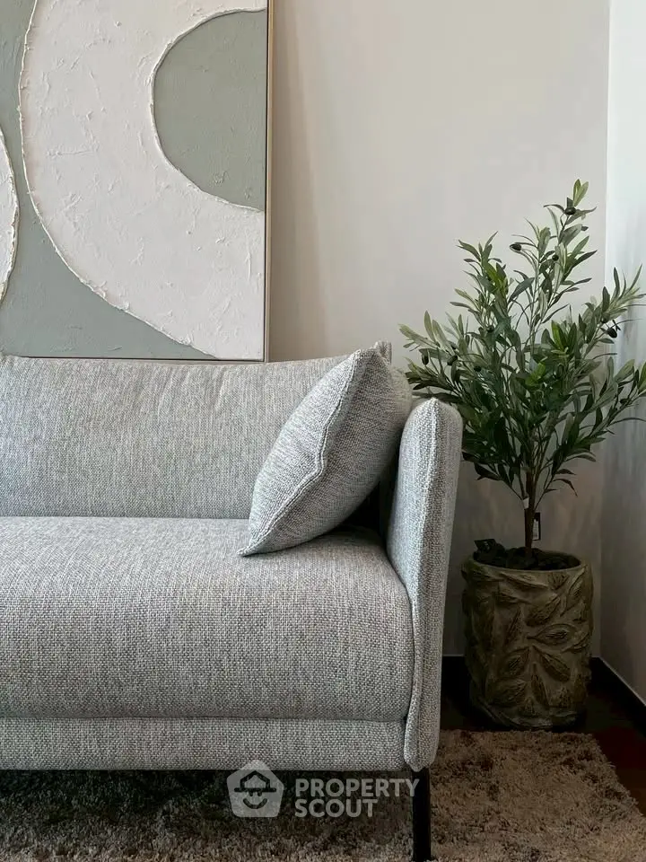 Stylish modern living room with elegant grey sofa and decorative plant