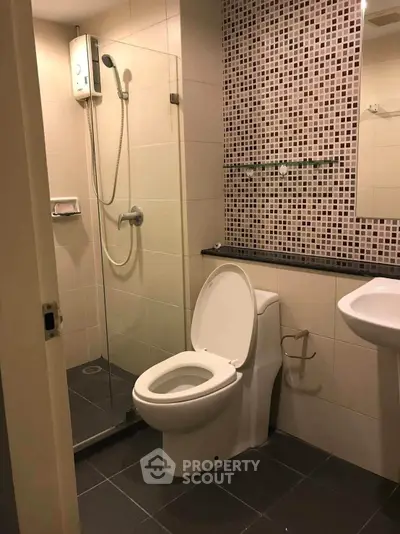Modern bathroom with glass shower and stylish tile design.