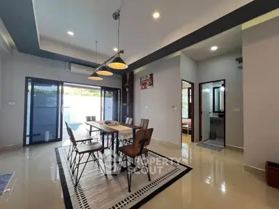 Modern dining area with stylish lighting and large windows in a contemporary home.