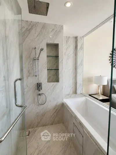 Luxurious marble bathroom with modern shower and bathtub in elegant home.