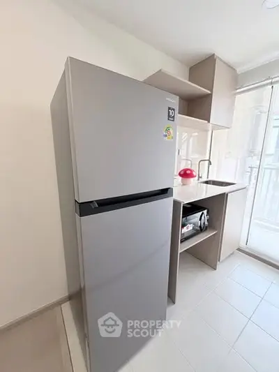 Modern kitchen with sleek fridge and compact design, perfect for urban living.