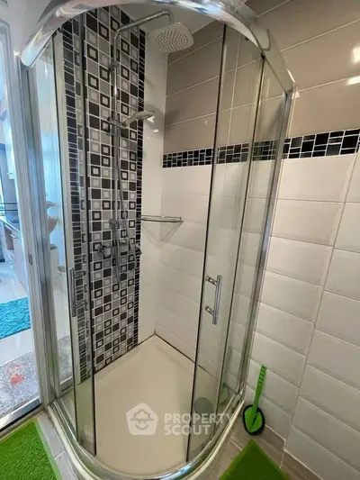 Modern bathroom with glass shower enclosure and stylish tile design