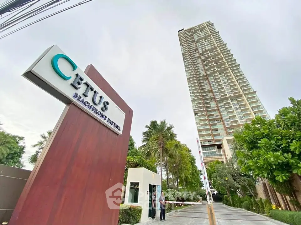 Stunning beachfront high-rise building with lush greenery and modern entrance at Cetus Beachfront Pattaya.