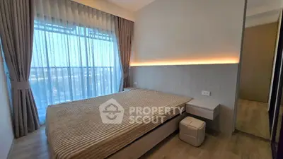 Modern bedroom with large window and elegant curtains in a stylish apartment.