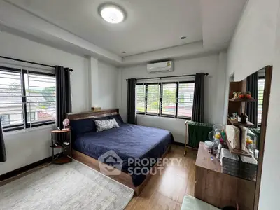 Spacious bedroom with modern decor and large windows offering natural light and scenic views.