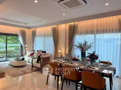 Luxurious open-plan living and dining area with elegant decor and large windows.