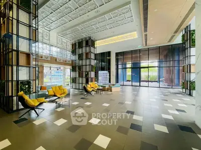 Luxurious modern lobby with high ceilings and stylish seating in a contemporary building.