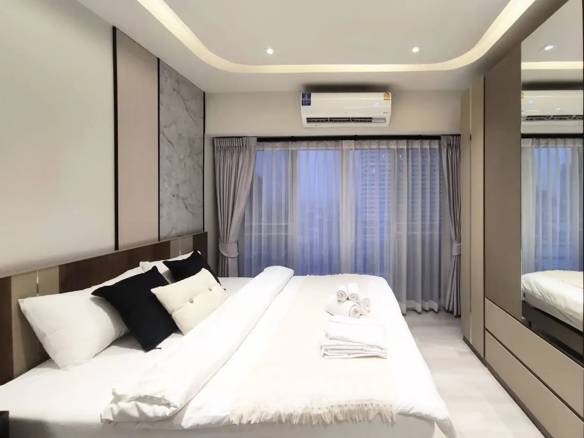 Luxurious modern bedroom with elegant decor and large windows for natural light.