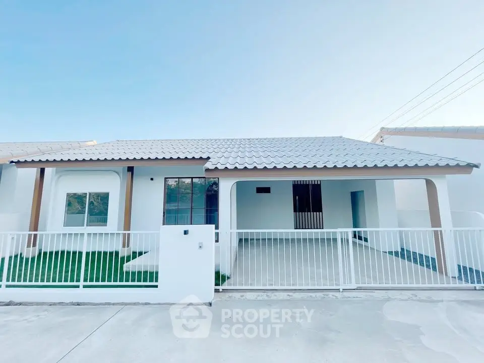 Charming modern single-story house with white facade and spacious driveway.