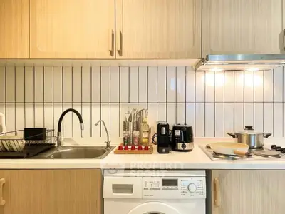Modern kitchen with sleek cabinetry, integrated washing machine, and stylish backsplash.