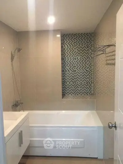 Modern bathroom with sleek bathtub and stylish tile design, perfect for relaxation and comfort.