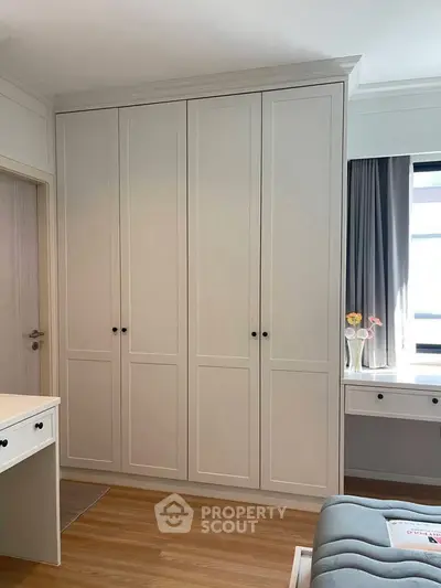 Elegant bedroom with built-in wardrobe and natural light, perfect for modern living.