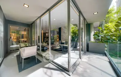 Luxurious modern living room with glass walls and lush greenery view