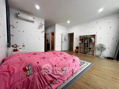 Spacious bedroom with pink bedding and modern decor, featuring ample storage and natural light.