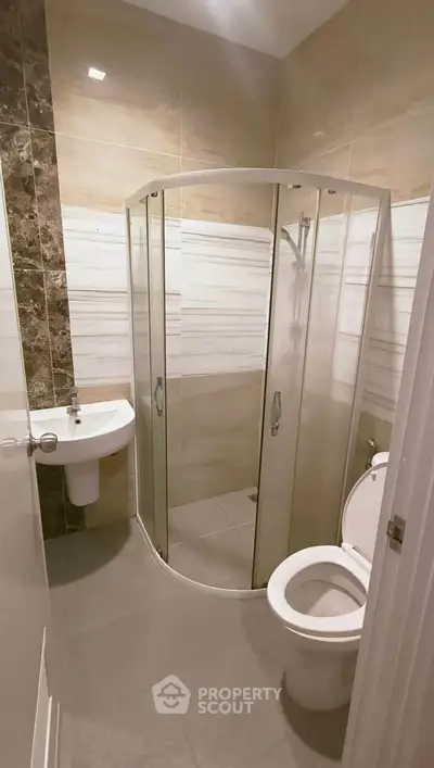 Modern bathroom with glass shower enclosure and sleek fixtures.