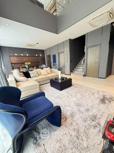 Luxurious modern living room with open kitchen, stylish furniture, and elegant decor in a spacious apartment.