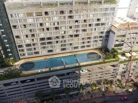 Modern high-rise building with rooftop pool and urban view, perfect for luxury living in the city.