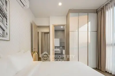 Modern bedroom with ensuite bathroom and large window offering natural light.