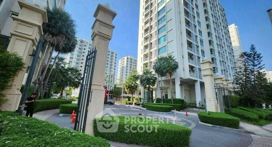 Luxurious high-rise apartment complex with lush landscaping and grand entrance.