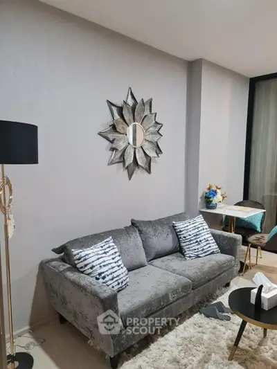 Stylish living room with plush gray sofa and decorative mirror, perfect for modern comfort.