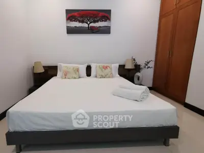 Spacious bedroom with modern decor and large bed, perfect for relaxation.