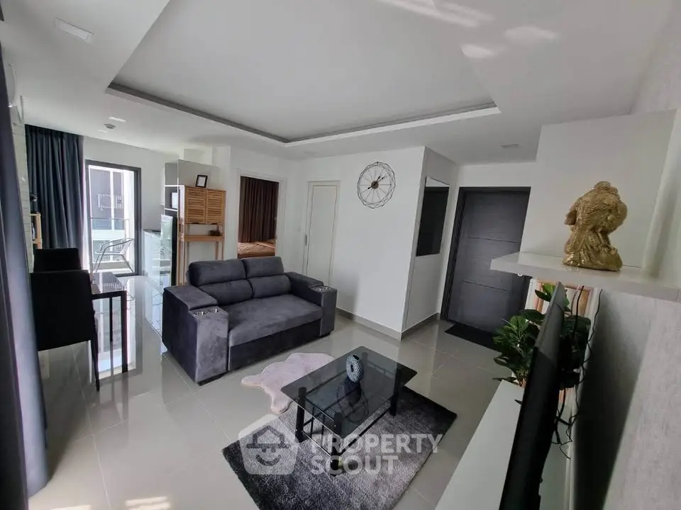 Modern living room with sleek design and balcony access, featuring a plush sofa and stylish decor.