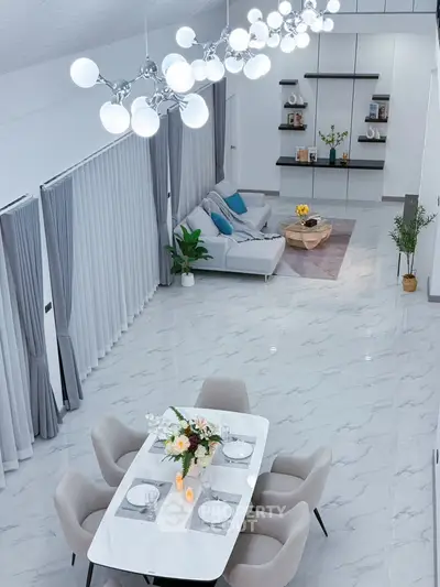 Luxurious open-plan living and dining area with modern decor and elegant lighting.