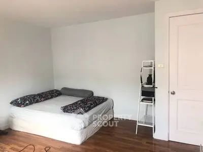 Spacious bedroom with minimalist decor and wooden flooring