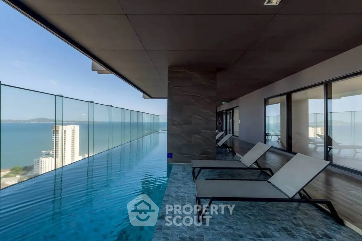 Luxurious rooftop infinity pool with stunning ocean view and modern lounge chairs.