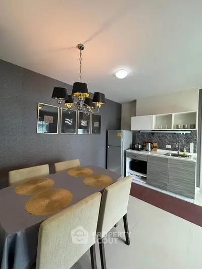 Modern dining area with elegant chandelier and sleek kitchen design, perfect for stylish living.