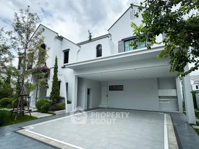 Modern white exterior house with spacious driveway and lush greenery