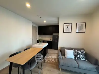 Modern open-plan living room with stylish kitchen and dining area, featuring contemporary furniture and decor.