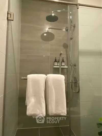 Modern bathroom with glass shower enclosure and sleek fixtures.