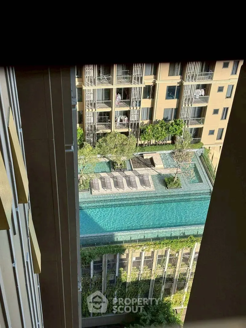 Luxurious apartment complex with rooftop pool and lush greenery view.