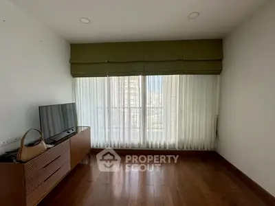 Spacious living room with large window and modern TV stand, perfect for relaxation.