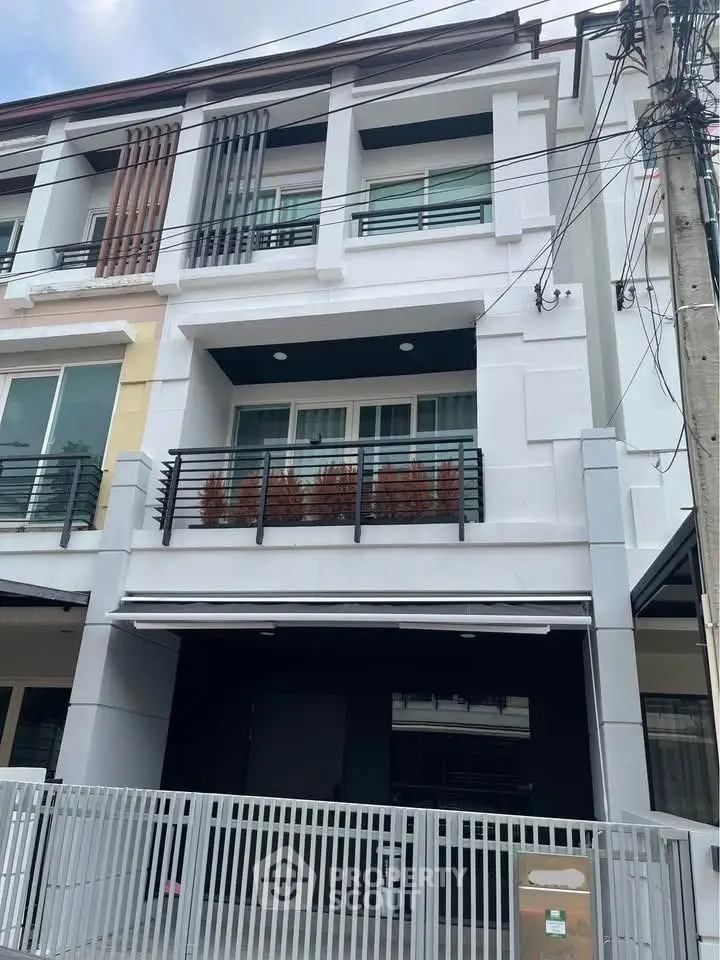 Modern townhouse exterior with balcony and gated entrance, ideal for urban living.