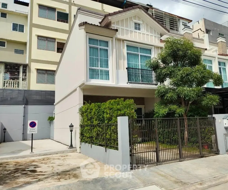 Charming two-story house with lush greenery and modern facade in urban setting.
