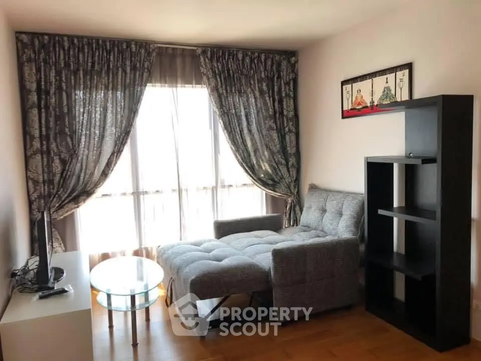 Cozy living room with stylish sofa, elegant curtains, and modern shelving unit.