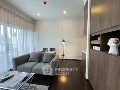 Modern living room with stylish decor and city view, featuring a cozy sofa and elegant dining area.