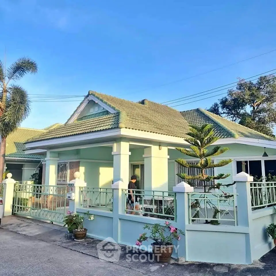 Charming single-story home with green roof and gated entrance in a serene neighborhood.