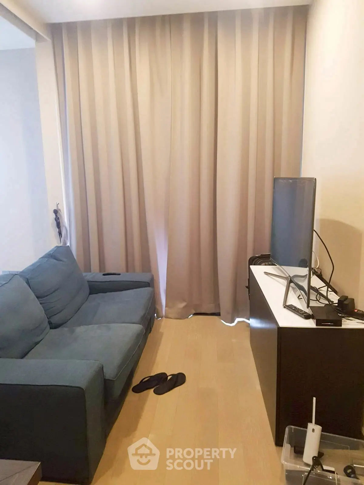 Cozy living room with blue sofa and modern TV setup, ideal for relaxation.