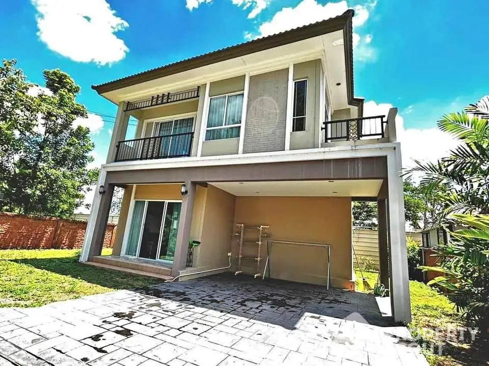 Modern two-story house with spacious balcony and lush garden